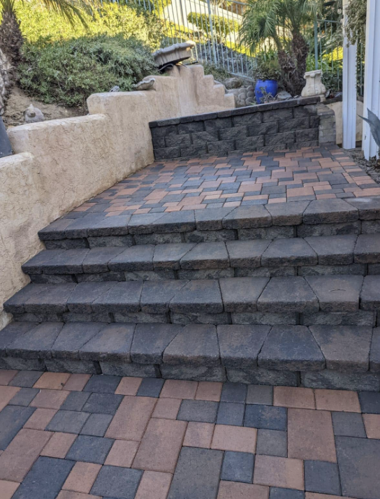 Finished paver patio with block steps and a matching retaining wall