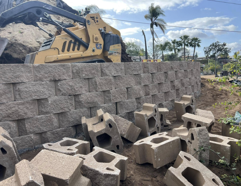 Block retaining wall being built on a hillside job